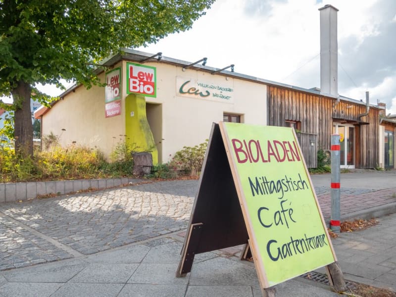 Ladengebäude von Lew Bio in der Neustadt in Prenzlau mit Aufsteller für Bioladen, Mittagstisch, Café und Gartenterrasse | © Agentur Reichenberger