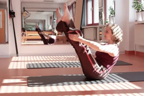 Rumpfübung auf der Matte im lichtdurchfluteten Studioraum | © Pilates Studio Hamburg / Sabine Büttner Photography