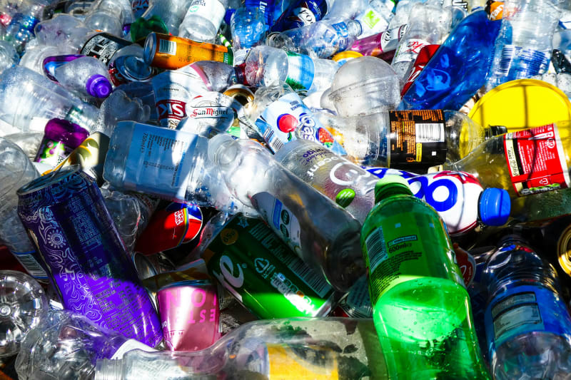 Ansammlung von Plastikflaschen und Getränkedosen als Symbol für Umweltverschmutzung