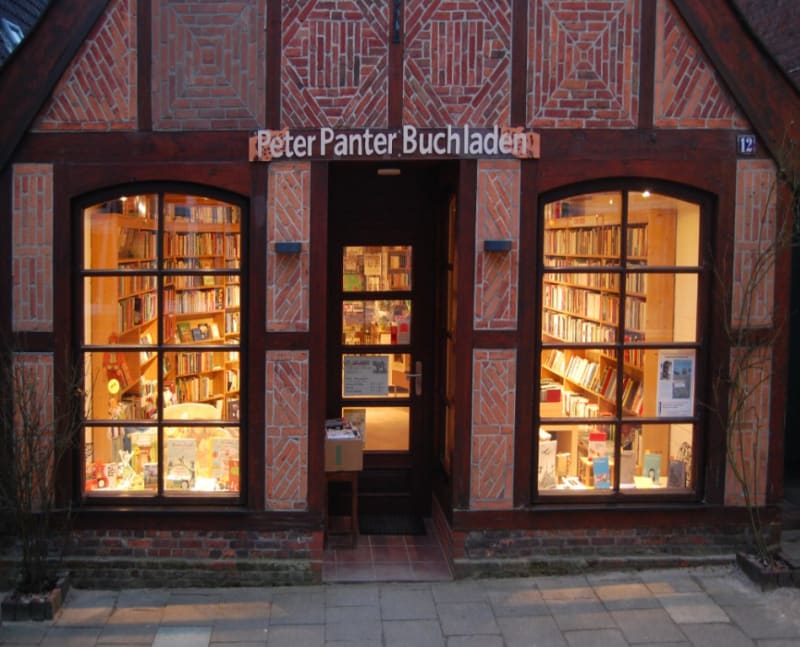 Beleuchtete Schaufensterfront des Peter Panter Buchladens mit Schriftzug an der Zingelstraße in Meldorf | © Peter Panter Buchladen