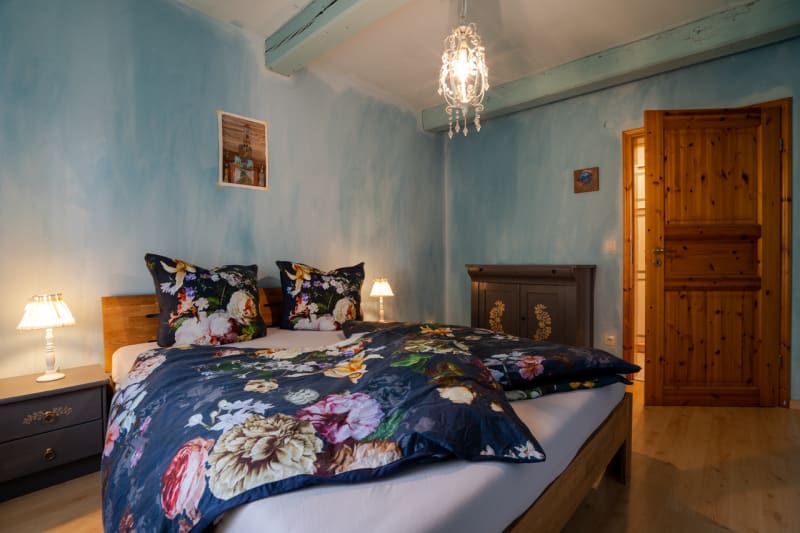 Schlafzimmer mit Blumenbettwäsche in der Ferienwohnung Rüm Hard | © Hof Edenswarf - Fotograf Sören Lang