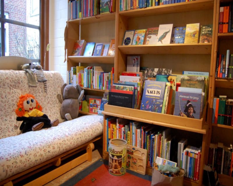 Leseecke mit Sofa und Kinderbuchabteilung im Peter Panter Buchladen | © Peter Panter Buchladen