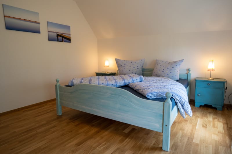 Schlafzimmer mit Holzdielen in der Ferienwohnung Klaar Kimming | © Hof Edenswarf - Fotograf Sören Lang