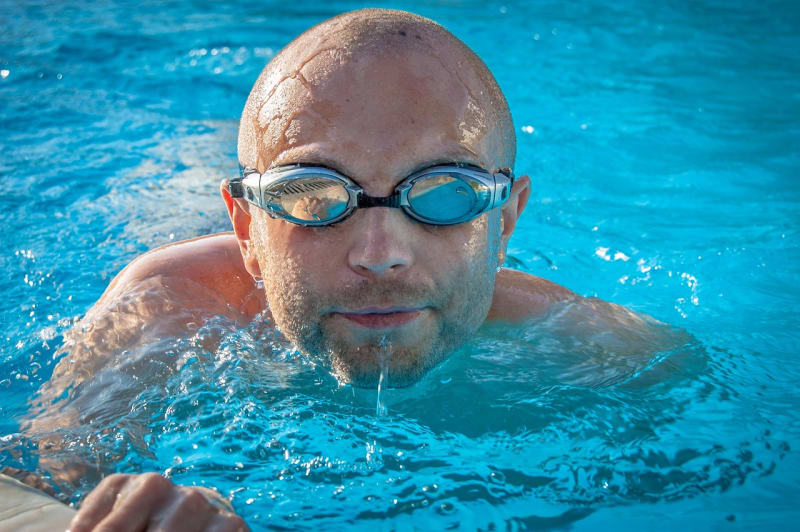 Mann mit SChwimmbrille in Schwimmbecken