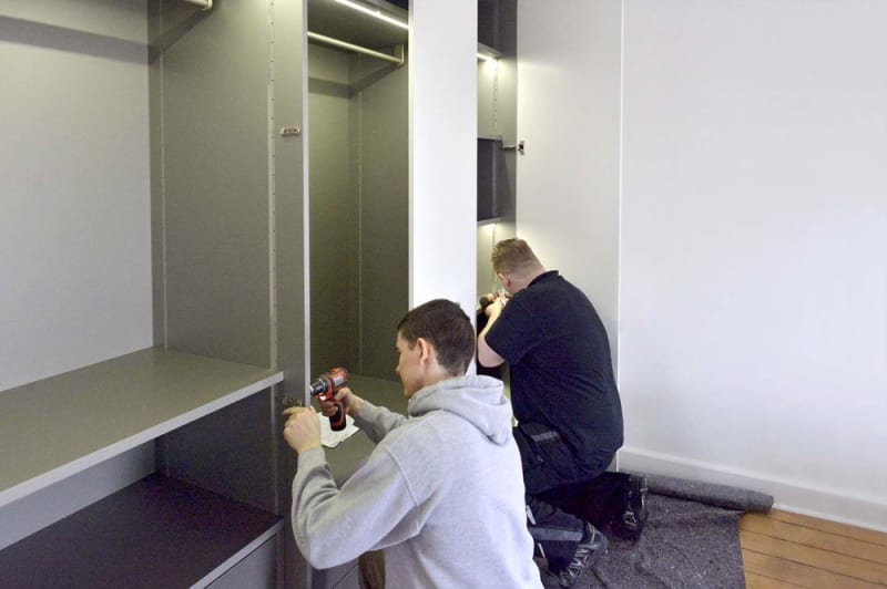 Zwei Tischler von W&A montieren einen raumhohen Einbauschrank beim Kunden | © W&A Wohnen / Tischlerei