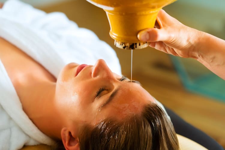 Eine Frau genießt eine Ayurveda-Ölmassage in einem Spa