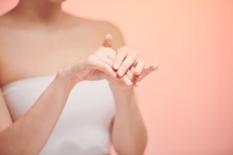 Das Mädchen cremt sich die Hände mit einer pflegenden Kosmetikcreme ein, die für jugendliche Haut und Hautelastizität sorgt.
