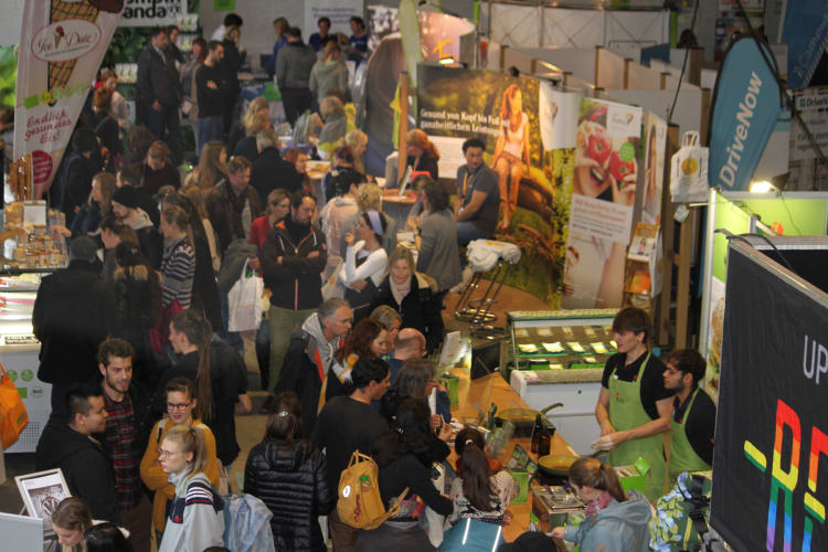 Eine Menge Menschen in einer Messehalle mit Ständen (c) Ecoventa Services UG