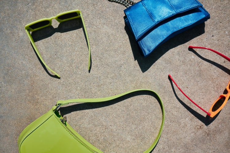 Grüne Handtasche, grüne und ornage Sonnenbrielle und blaue Handtasche  null