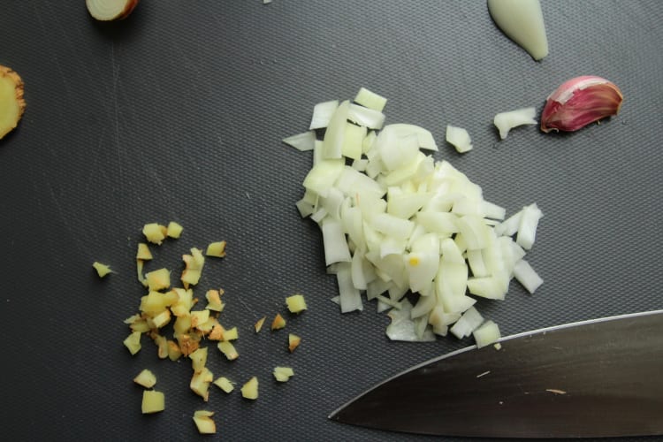 Gehackte Zwiebeln auf schwarzem Brett null