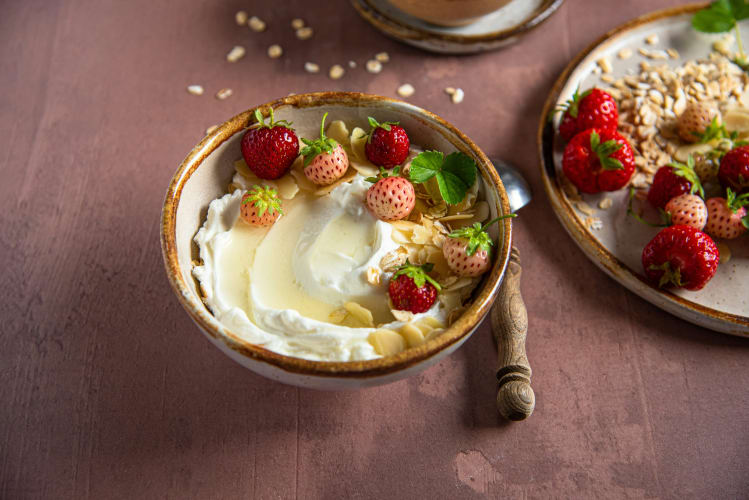 Eine Schüssel mit skyr, Erdbeeren und Mandelblättchen  null