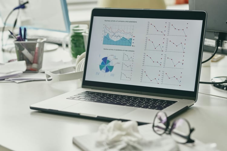 Laptop mit Streudiagrammen und Auswertungen auf einem Schreibtisch © Getty Images / Unsplash+