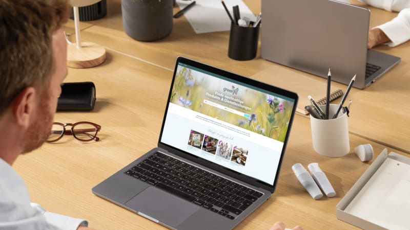 mann der am macbook sitzt und auf der greenya webseite Artikel liest
