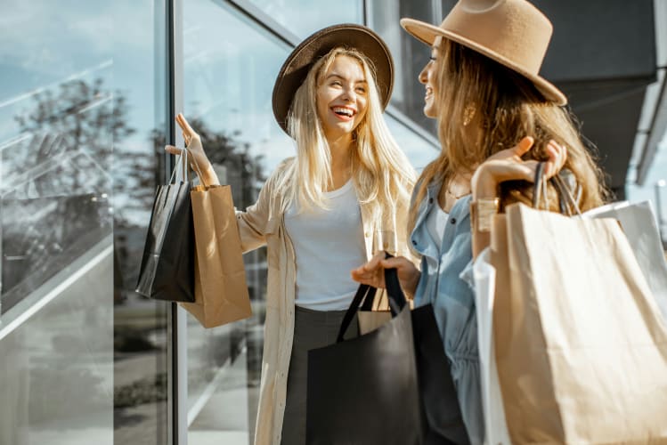 Zwei glückliche junge Frauen mit Shoppingtüten in der Hand null