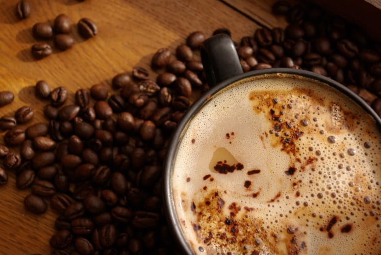 fair gehandelte Kaffeebohnen und Kaffee auf einem Tisch.