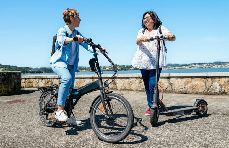 Frauen fahren auf E-Scooter durch die Stadt 