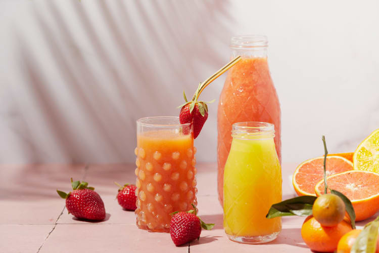 Obst und Säfte auf einem Tisch mit Erdbeeren dekoriert