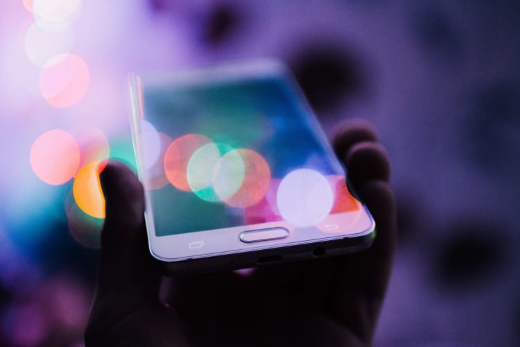 Smartphone in schimmerndem bunten Licht