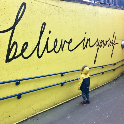 Kind vor Wand mit der Aufschrift believe in yourself Katrina Wright auf Unsplash