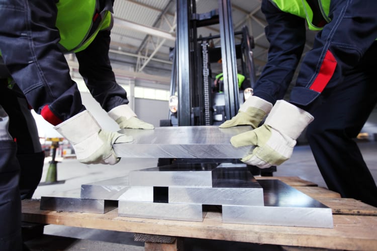  Arbeiter bei der Entnahme von Aluminiumknüppeln in der CNC-Maschinenhalle null
