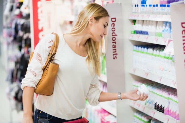 Seitenansicht einer Frau, die im Supermarkt ein Deodorant auswählt null