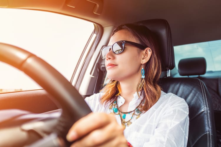 Eine Frau, die gut gelaunt Auto fährt.