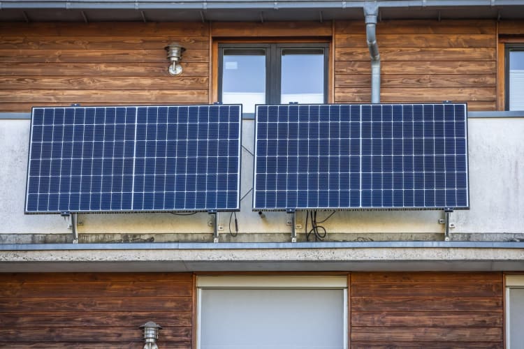 Balkon-Solaranlage. Solarmodul an der Balkonwand. Mit Mini-PV-Anlagen eigenen Strom erzeugen – einfach anschließen und loslegen