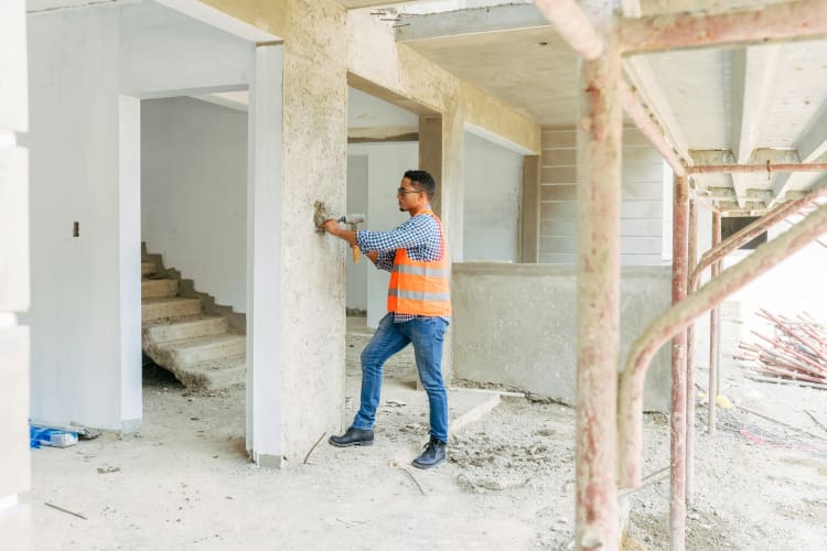 Ein Handwerker renoviert einen Wohnraum