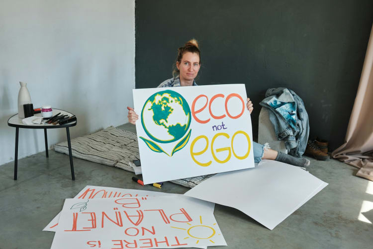 Frau hält Plakat mit Titel eco not ego drauf hoch null