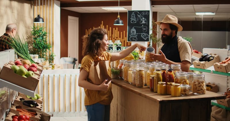 Kunde spricht mit Verkäufer in einem nachhaltigen Bioladen null