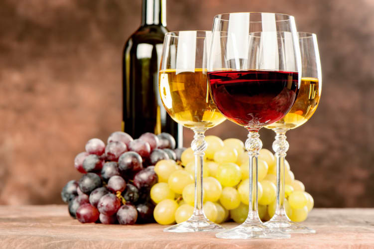 Rot- und Weißwein vor Trauben und Flaschen null