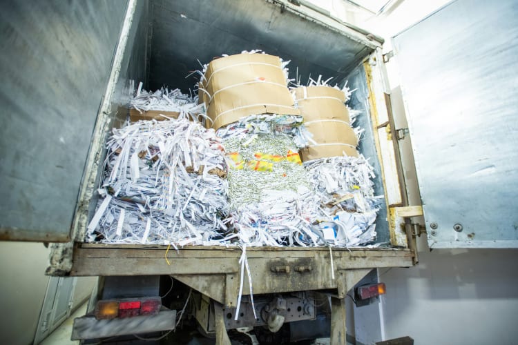 LKW mit offener Tür und stapelweise Papier zur Entsorgung Recycling null