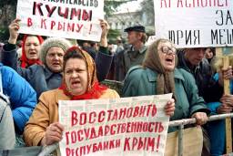 Protesters shouting, holding signs written in Russian