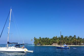 Barco a vela e pesqueiro em frente a ilha paradisíaca
