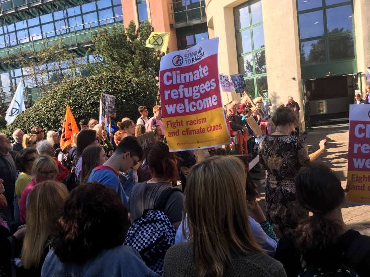 Crowd with banners in front of modern buildings