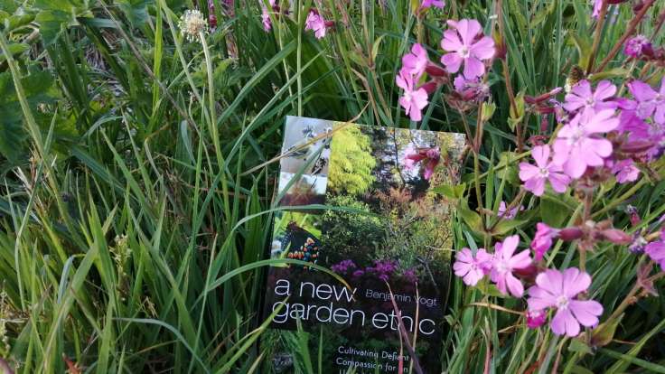 Picture of New Garden Ethic book in amongst grass & flowers