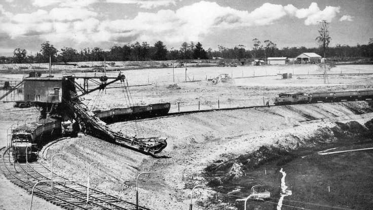 Black and white photo of open mine, with scoopy shovelly thing.