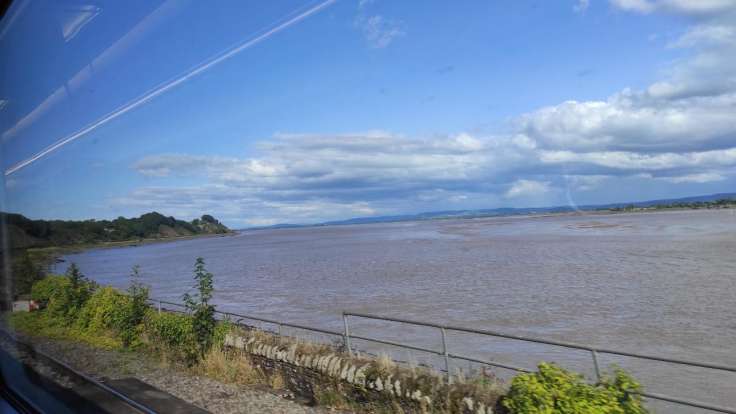 Skewiff view of a tidal river through a train window