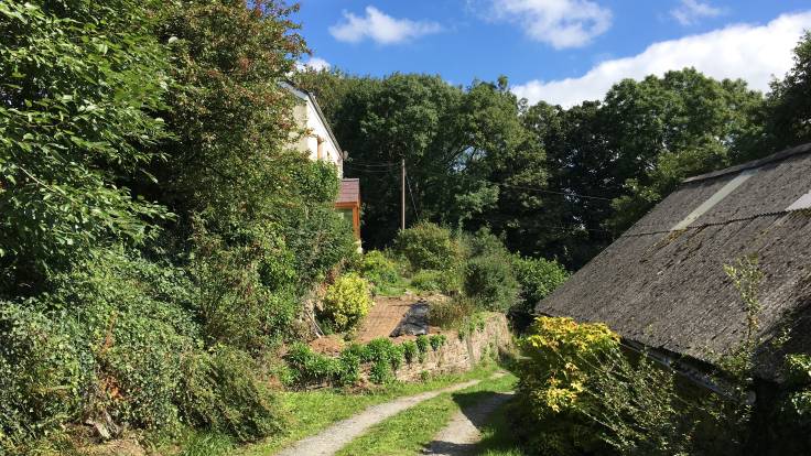 Track leading past barn and brick path going up to house, blue sky & cloud