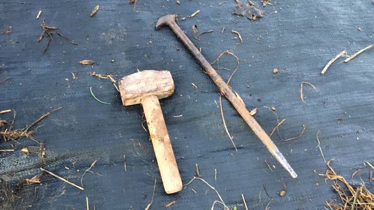 Lump hammer and poky metal stick on sheet mulch