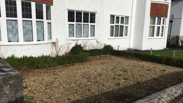 Gravel front garden of semi-detached white house