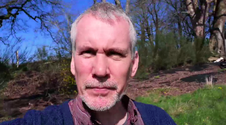 Middle aged man squinting through the sun into the mobile phone camera