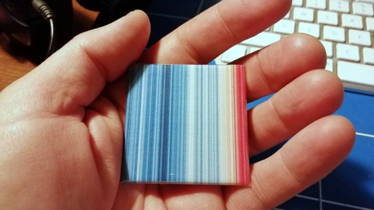 Hand holding stripey colour badge