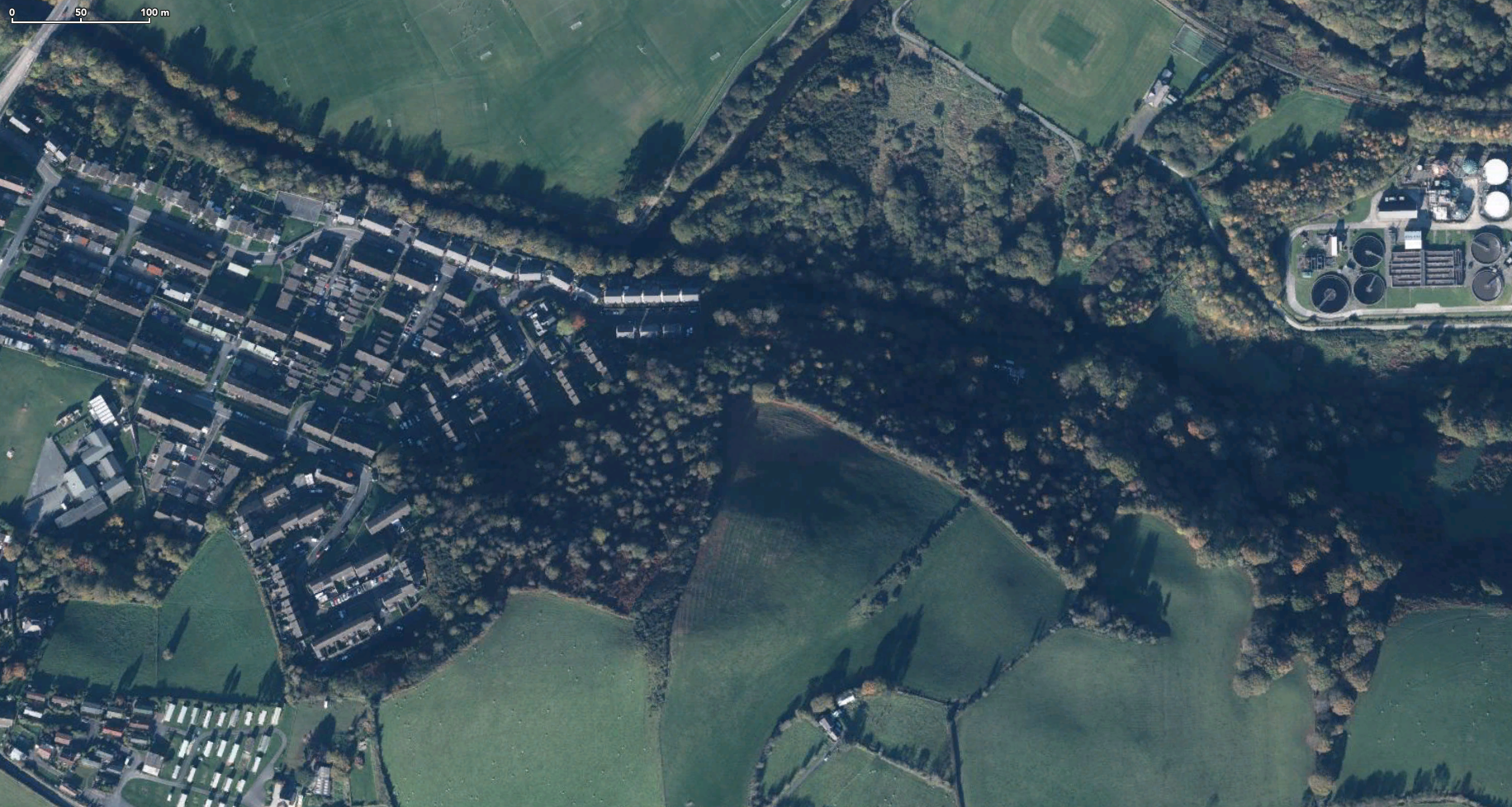 Satellite photo of wooded area at edge of town