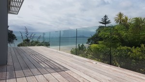 Frameless glass balustrade overlooking trees & beach