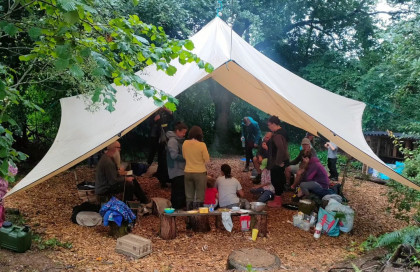 People under makeshift canvas shelter