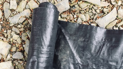 Roll of woven plastic sheet mulch