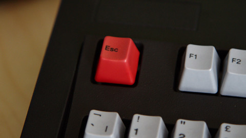 Close-up of shiny red escape key on keyboard