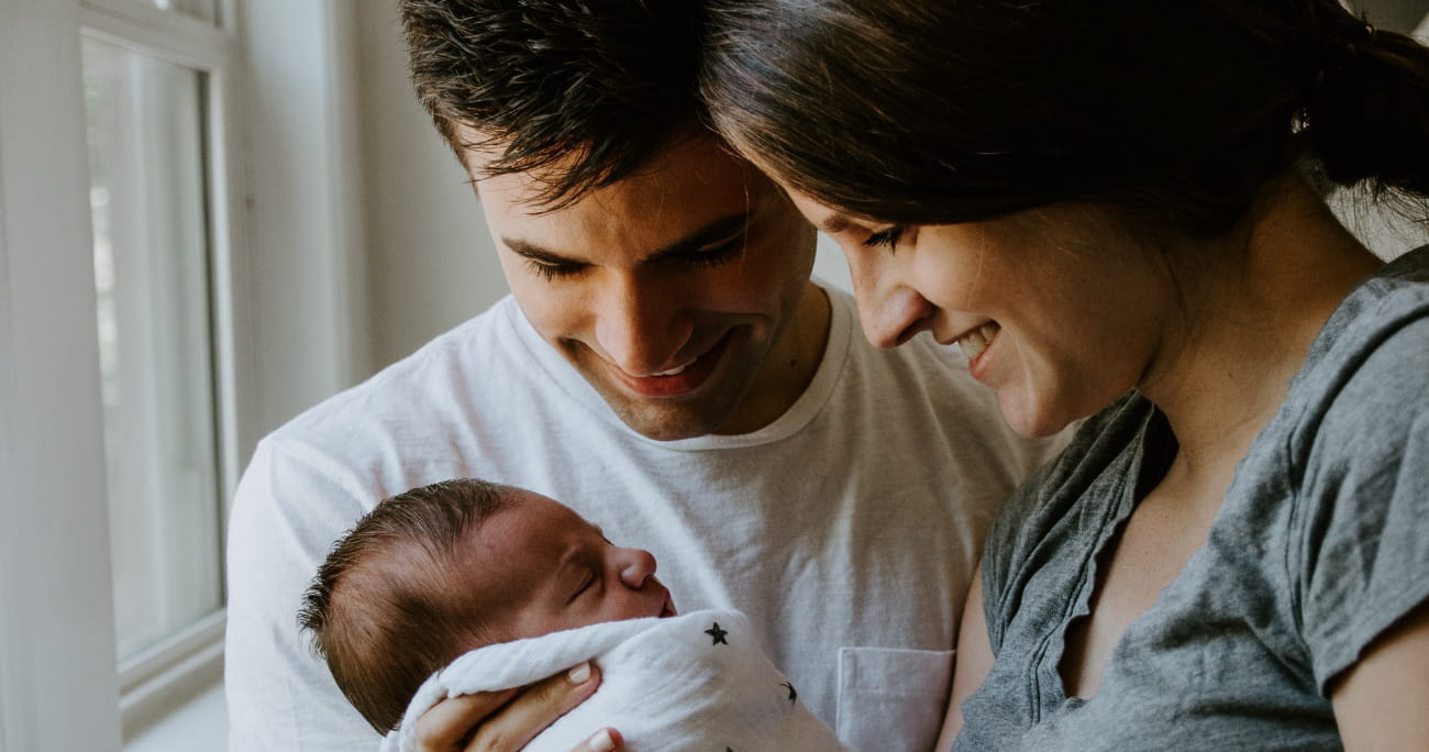 young parents staring at their newborn baby