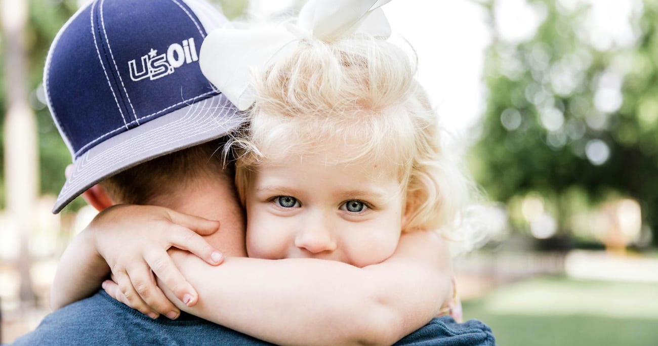 Young girl looking over the shoulder of her father